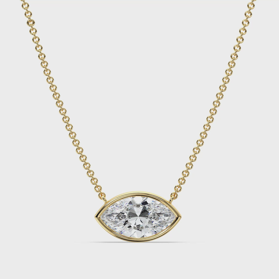 Close-up video showcasing a stunning 2 Carat Marquise-Cut Lab-Grown Diamond Bezel-Set Solitaire Pendant Necklace in 18K Yellow Gold. The video highlights the diamond's brilliance, the sleek bezel setting, and the rich, warm tone of the yellow gold chain, offering a luxurious and elegant design perfect for any occasion