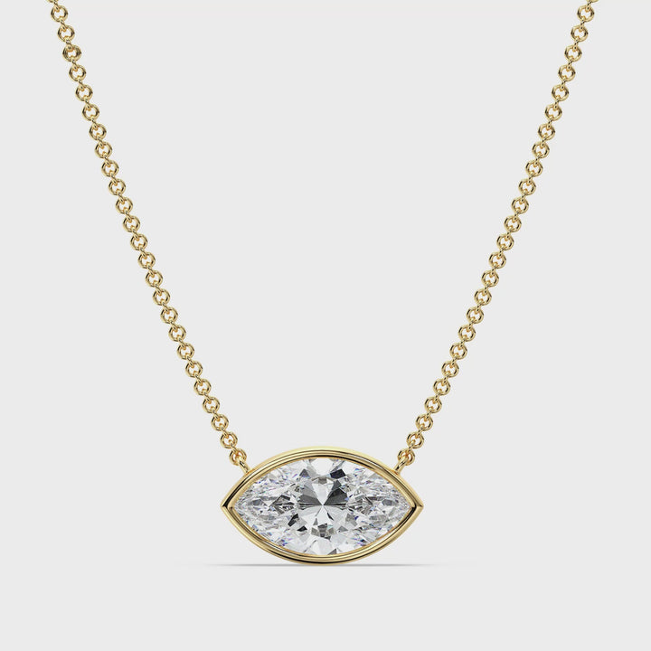 Close-up video showcasing a stunning 2 Carat Marquise-Cut Lab-Grown Diamond Bezel-Set Solitaire Pendant Necklace in 18K Yellow Gold. The video highlights the diamond's brilliance, the sleek bezel setting, and the rich, warm tone of the yellow gold chain, offering a luxurious and elegant design perfect for any occasion