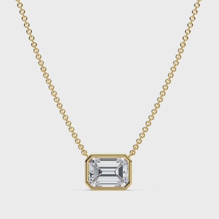 Video showcasing a stunning 2.00ct Emerald-Cut Lab-Grown Diamond Solitaire Pendant Necklace in Yellow Gold. The diamond, securely set in a sleek bezel setting, sparkles brilliantly as the pendant gently rotates to reveal its dazzling facets. The 18K Yellow Gold adds a warm, classic touch to the design, complemented by a delicately crafted chain for a seamless, elegant look