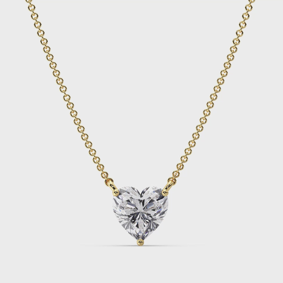 A close-up video showcasing the Yellow Gold variant of the 2.00 Carat Heart-Shaped Lab-Grown Diamond Solitaire Pendant Necklace. The pendant features a dazzling IGI Certified 2.00ct heart-cut diamond with E color and VS clarity, set in a secure prong setting. The warm 18K Yellow Gold frame enhances the brilliance of the diamond, creating a timeless and elegant look. The video captures the pendant's intricate details and radiant sparkle, accompanied by a delicate chain, perfect for any special occasion.